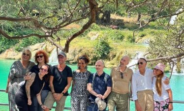 Group of people in the background with Wadi Darbat waterfall in winter