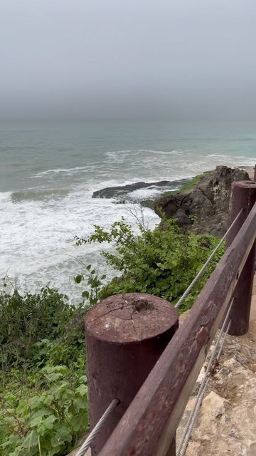 Mughsail Beach with turquoise water and rocky cliffs in the background
