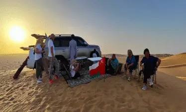 Travelers walking on sand dunes Salalah Desert Safari