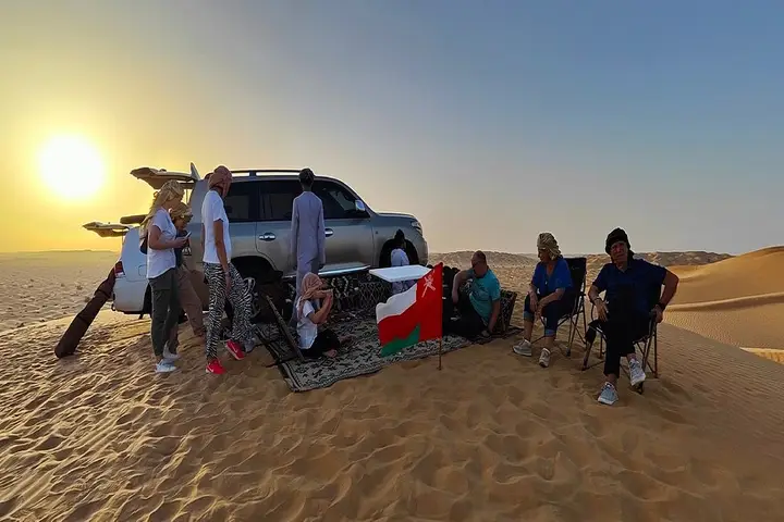 Travelers walking on sand dunes Salalah Desert Safari