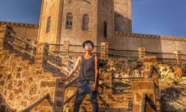 Adult standing in front of Taqah Castle in Salalah