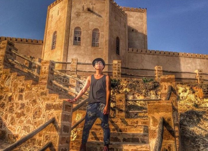 Adult standing in front of Taqah Castle in Salalah