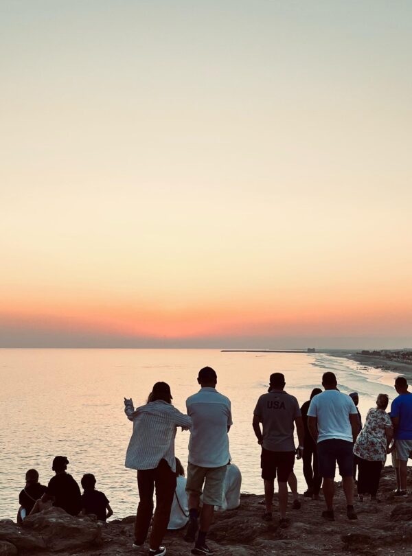 Tour group with guide witnessing the sunset at Taqah Viewpoint