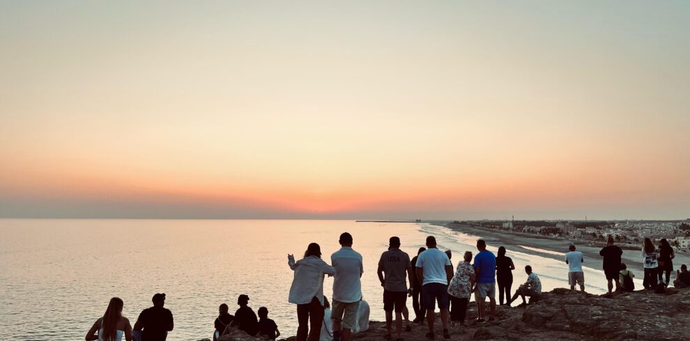 Tour group with guide witnessing the sunset at Taqah Viewpoint