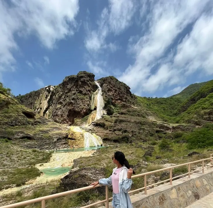 Travelers walking near waterfalls at Wadi Darbat, East Salalah private tour