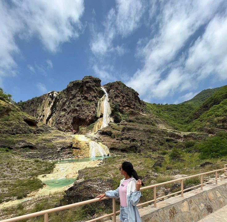Tourists enjoying the waterfall at Wadi Darbat