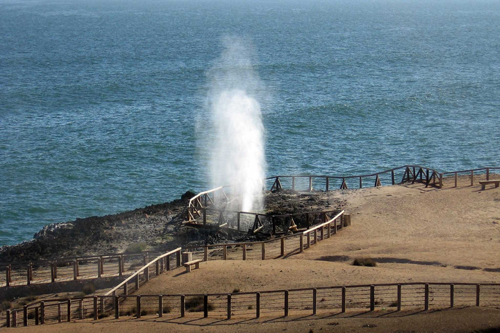 Wide view of Mughsail Beach coastline with rocky cliffs and sandy shore